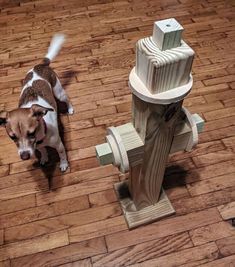 a dog standing next to a fire hydrant on a wooden floor in front of it