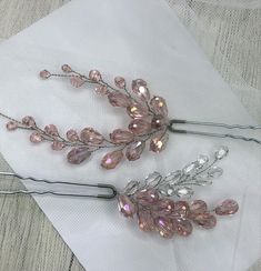 two pink hair pins sitting on top of a white cloth