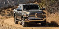 a silver ram truck driving down a dirt road