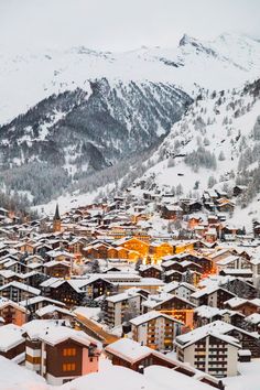 a snowy town with mountains in the background