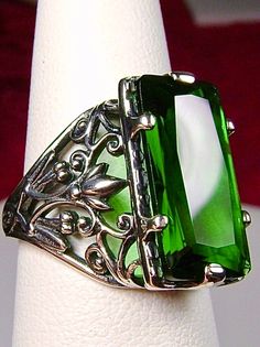 Green Emerald Ring Baguette Design#32 Introducing the Baguette D32, a stunning piece of wearable art that pays homage to the opulent Victorian era. Crafted with meticulous attention to detail, this exquisite filigree Antique reproduction in sterling silver is sure to captivate anyone with a love for vintage-inspired jewelry. At its center, lies a flawless 7ct green emerald gemstone, radiating a dazzling hue that catches the light with every movement. The baguette rectangle-cut gemstone measures Antique Emerald Jewelry For Formal Occasions, Elegant Formal Jewelry With Rectangular Stone, Elegant Jewelry With Rectangular Stone For Formal Occasions, Elegant Rectangular Stone Formal Jewelry, Green Baguette-cut Art Deco Jewelry, Elegant Rectangular Jewelry For Evening, Green Rectangular Jewelry For Party, Classic Emerald Jewelry For Evening, Victorian Emerald Cut Jewelry For Formal Occasions