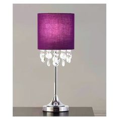 a table lamp with purple shade and crystal beads on the base, sitting on top of a