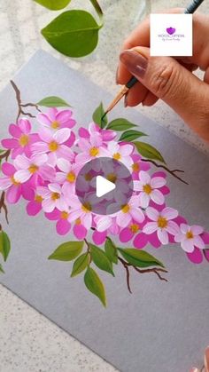 someone is painting flowers on a piece of paper