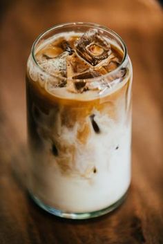 an iced drink in a glass on top of a wooden table