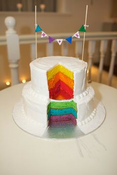 a multi colored cake with flags on top