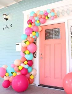 a pink door and some balloons on the front porch