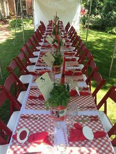 a long table set up with red and white checkered cloths for an outdoor party