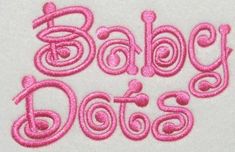 the word baby is spelled in pink thread on a white surface with an embroidered design