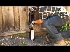 a man working on a wooden fence