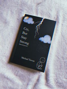 a book sitting on top of a bed covered in white sheets and blankets with lightning coming out of the clouds