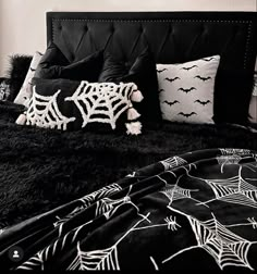 a black and white photo of a bed with spider webs on the pillow covers