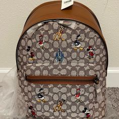 Disney 50th Anniversary Coach Backpack Brown Disney Bags For Everyday Use, Disney Style Brown Bag For Everyday Use, Disney Everyday Brown Bags, Brown Disney Backpack, Disney Style Brown Backpack For Disney Trips, Disney Brown Travel Bags, Disney Style Brown Travel Bag, Coach Backpack Purse, Coach Parker