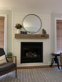 a living room with a fire place and mirror on the wall above it's mantle