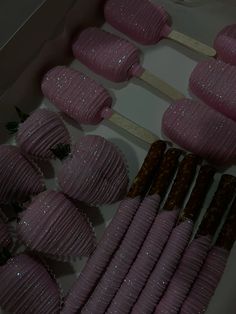 there are many pink desserts on sticks in the box and ready to be eaten