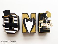 the letters are decorated with black and gold paper, including a top hat, bow tie, and balloon