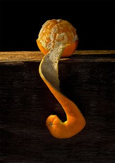 an orange peel with the shape of a seahorse on it's side sitting on a wooden surface