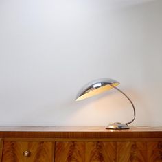 a desk lamp sitting on top of a wooden dresser