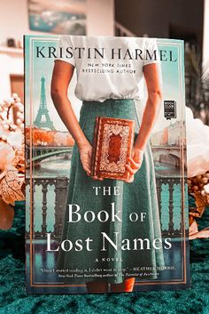 the book of lost names by kristyn harmel is sitting on a bed