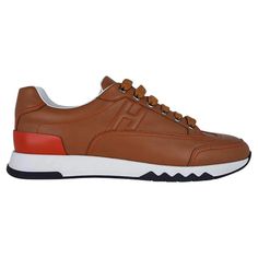 For Sale on 1stDibs - Mightychic offers a pair of Hermes Trail Sneakers featured in Gold calfskin. Accentuated with orange topstitch and rear detail. H logo on the side of sneakers. Designer Brown Calf Leather Sneakers, Luxury Calf Leather Sneakers With Stitched Sole, Brown Calf Leather Sneakers With Contrast Sole, Brown Calf Leather Sneakers With Rubber Sole, Brown Sporty Custom Sneakers With Leather Sole, Sporty Custom Brown Sneakers With Leather Sole, Casual Brown Sneakers With Leather Lining, Brown High-top Calf Leather Sneakers, Designer Brown Sneakers With Stitched Sole