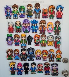 the pixel art is hanging on the wall in front of some buttons and magnets