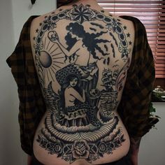 the back of a woman's body with tattoos on it