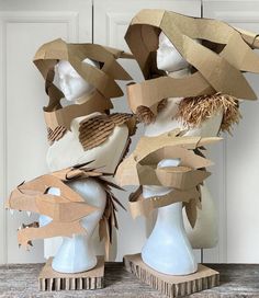 three mannequins with hats made out of cardboard on top of each other