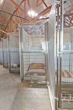 several cages are lined up in the middle of an empty room with no people inside