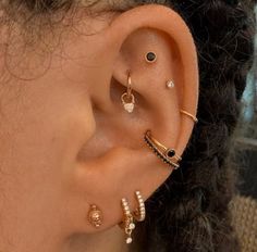 an ear with three different types of piercings on it's side, and one is