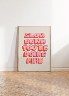 a poster with the words slow down you're doing fine on it in an empty room