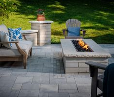 an outdoor fire pit with chairs around it