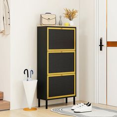 a black and yellow cabinet sitting next to a white door in a room with wooden floors