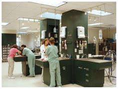 three women in scrubs are standing at the sink