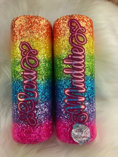 two personalized glitter can coolers with the word awesome written on them in pink, blue, yellow and green