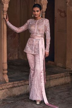 Blush pink jacket with all over embroidery using crystals, sequins, beads in abstract floral pattern. Paired with coordinating bell bottom pant and belt. Comes along with an inner bustier. - Aza Fashions Glamorous Long Sleeve Wedding Sets, Elegant Fitted Pink Sharara, Glamorous Fitted Pink Sharara, Pink Fitted Sharara For Evening, Fitted Pink Sharara For Evening, Pink Evening Sets With Resham Embroidery, Pink Long Sleeve Embellished Sets, Glamorous Pink Fitted Sharara, Bollywood Style Embellished Georgette Pant Set