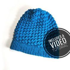 a blue knitted beanie hat with the words included video on it's side