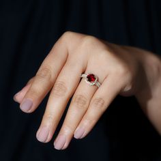 a woman's hand with a ring on top of her finger and an oval shaped diamond in the middle