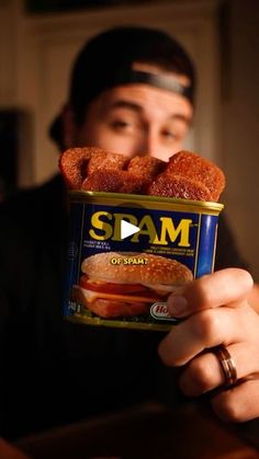 a man holding up a can of spam