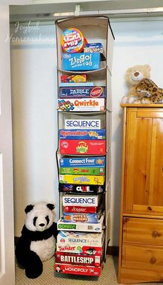 a stuffed panda bear sitting in front of a stack of children's books next to a closet