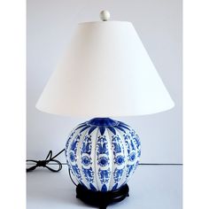 a blue and white lamp sitting on top of a table next to a light shade