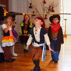 children dressed up in costumes standing on a wooden floor