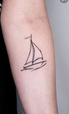 a small sailboat tattoo on the arm