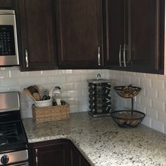 a kitchen with brown cabinets and marble counter tops