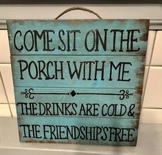 a sign that says, come sit on the porch with me the drinks are cold and the friends free