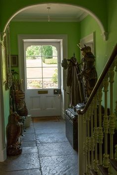 an entry way with green walls and wrought iron railings