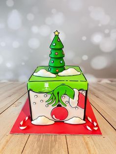 a card with a christmas tree on top and snow around the edges, sitting on a wooden table