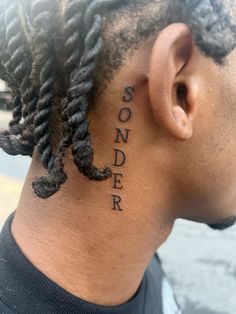 the back of a man's head with dreadlocks and words on it