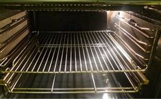 an open oven door with the light shining on it's rack and bottom shelf