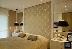 a bedroom with a bed, mirror and lights on the wall above it is decorated in neutral colors