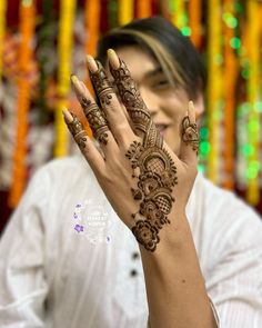 a woman holding her hands up with hendi tattoos on it's palms and fingers