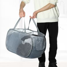 a man holding a large gray bag with mesh linings on the bottom and sides